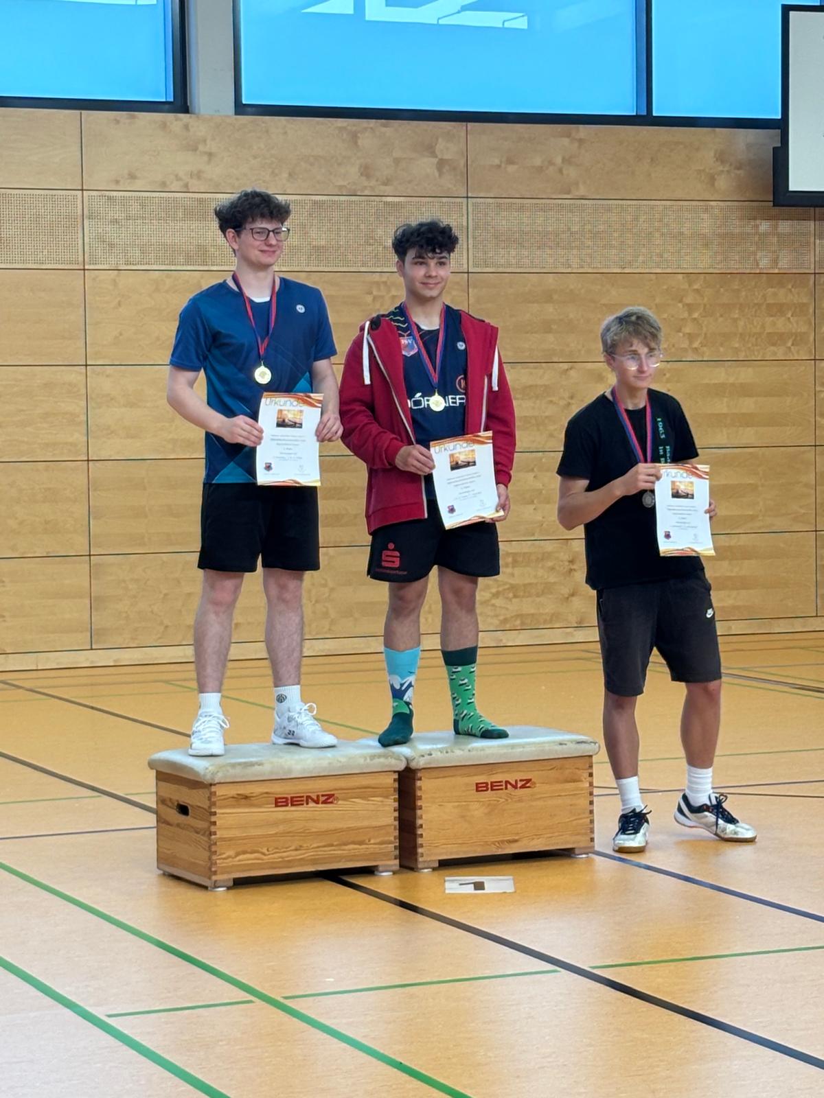 Siegerpodest der Jungen mit Urkunde und Medaille